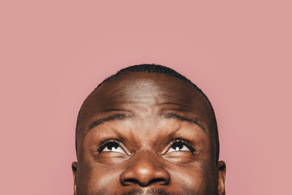 Happy Young Black Man Smiling And Looking Up