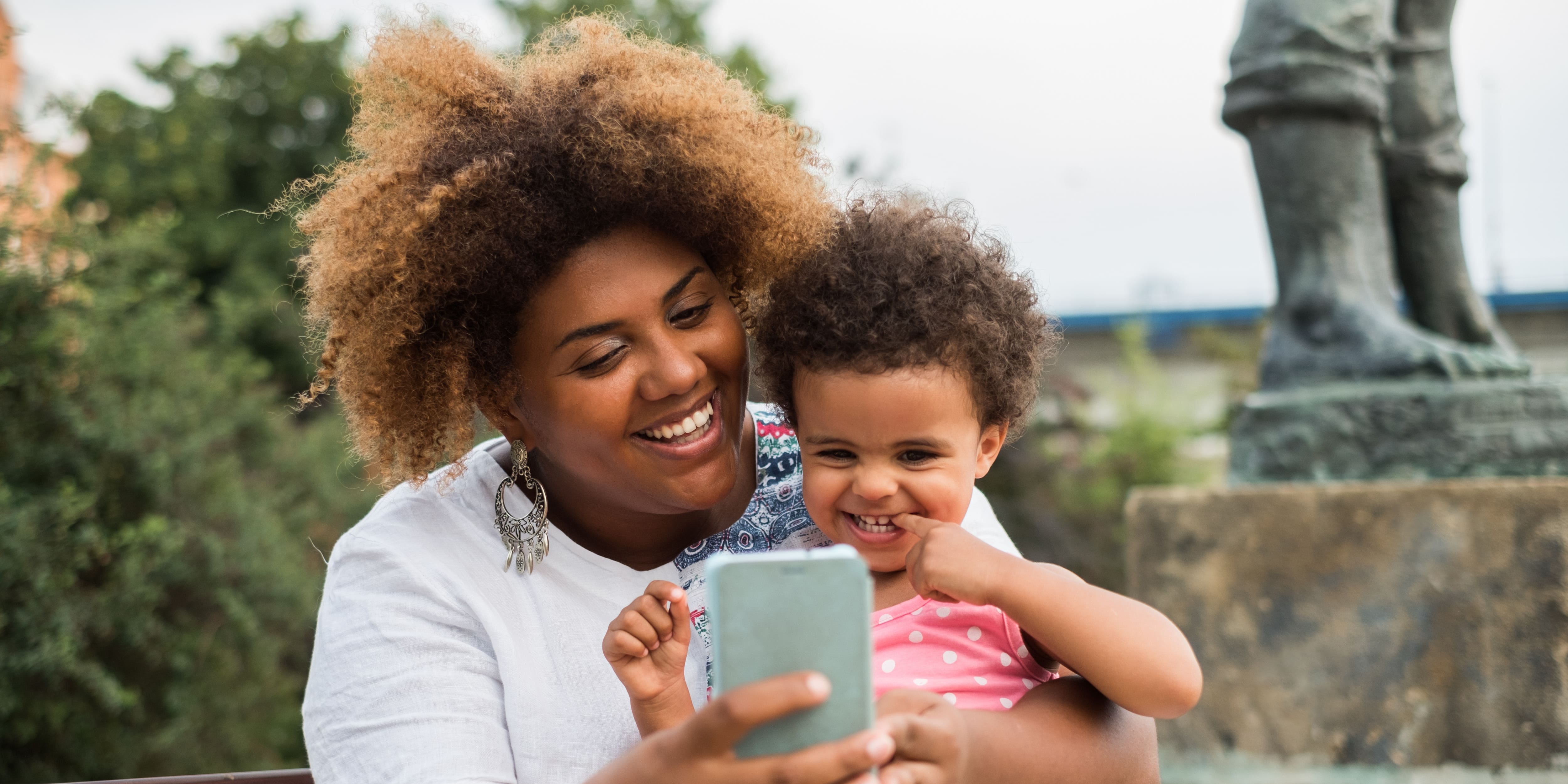 woman smiling with her child on a call